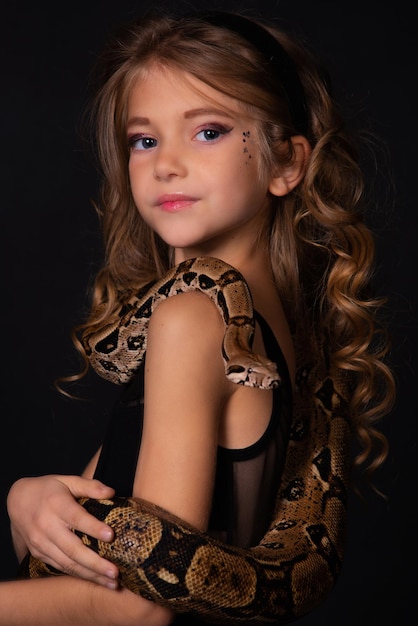 Girl with a snake on her body on a black background