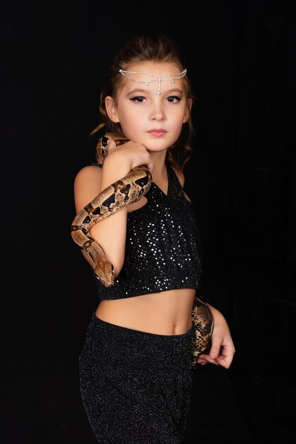 Girl with a snake on her body on a black background