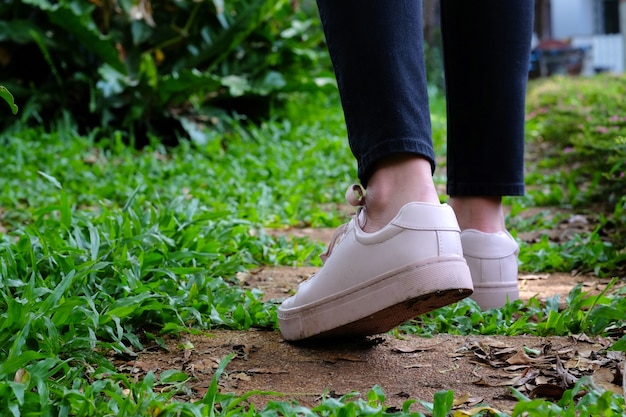 Girl with sneakers walking in park background