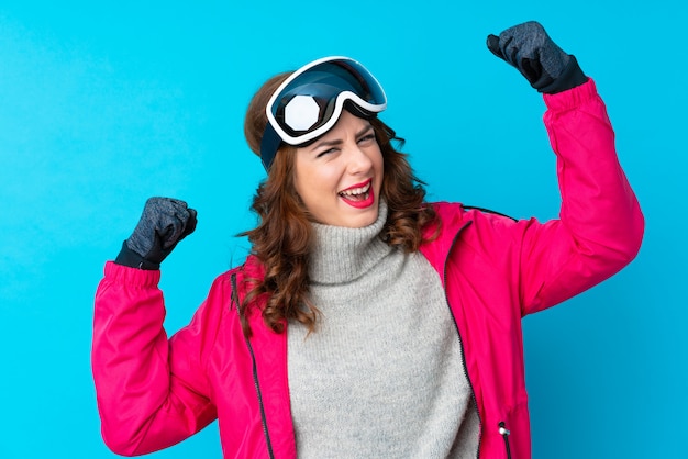 Girl with snow glasses over isolated wall