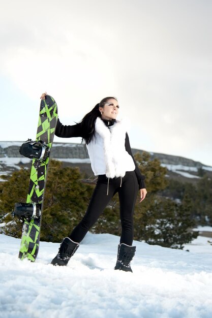 山にスノーボードを持っている女の子は