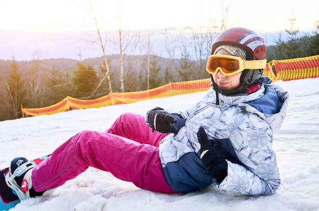 Girl with snowboard in snowy mountains