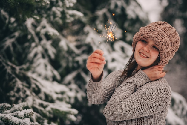 a girl with sparklers in a winter park