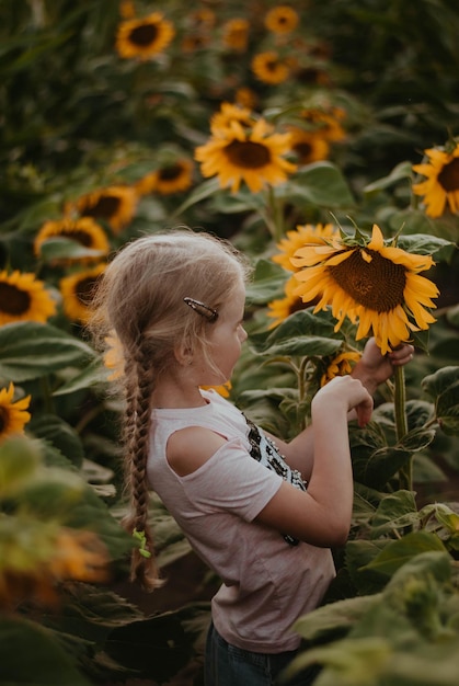 a girl with sunflowers. a child in a field of sunflowers
