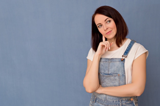 Girl with a surprised and pensive face on a blue background.