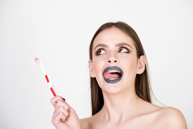 Girl with teeth braces and brush, has fashionable makeup