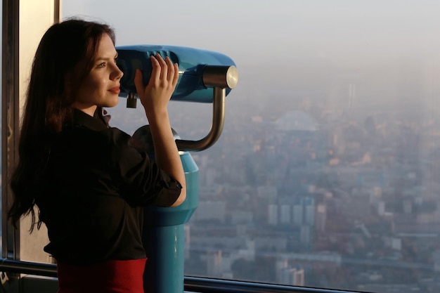 Girl with a telescope on the observation platform tourist