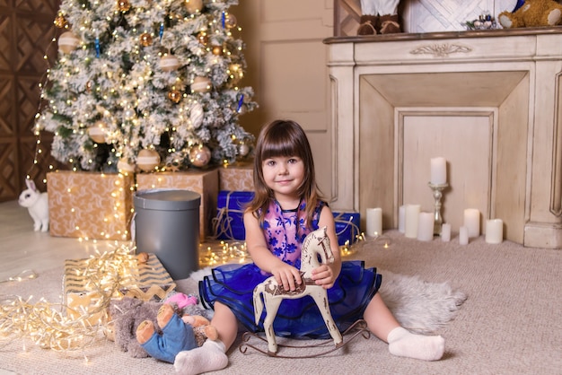 girl with toys near the christmas tree