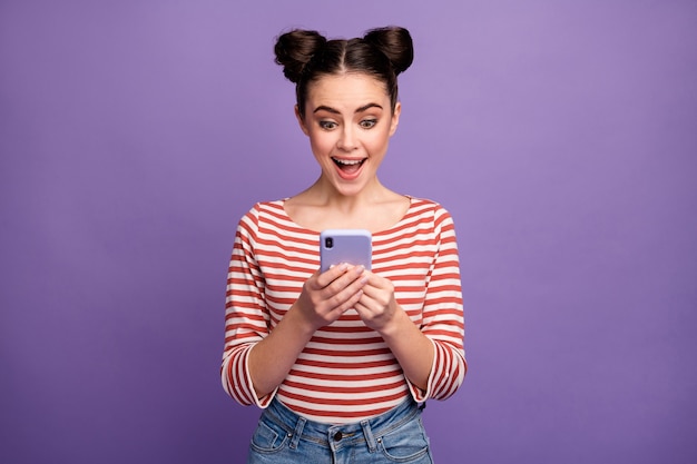 Girl with trendy hairstyle using phone isolated on purple