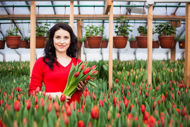 Girl with tulips grown in a greenhouse.