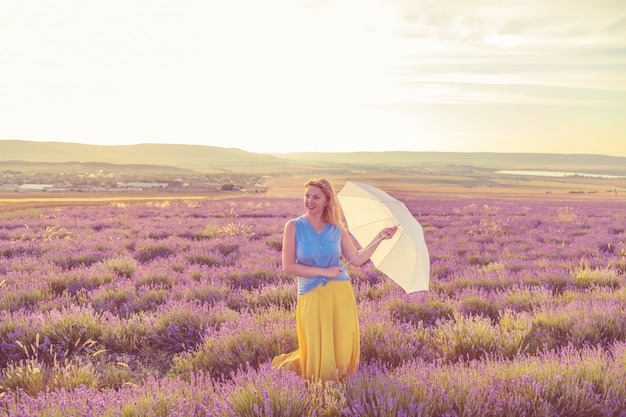 Ragazza con ombrello in un campo di lavanda