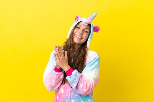 Girl with unicorn pajamas over isolated background applauding after presentation in a conference