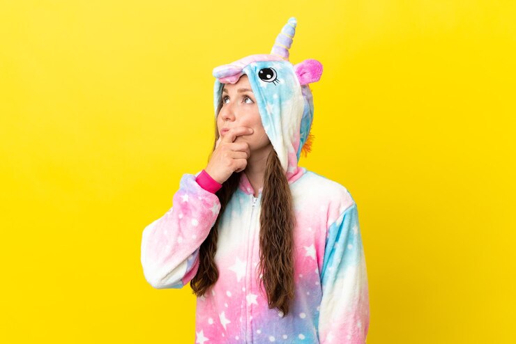 Photo girl with unicorn pajamas over isolated background having doubts and with confuse face expression