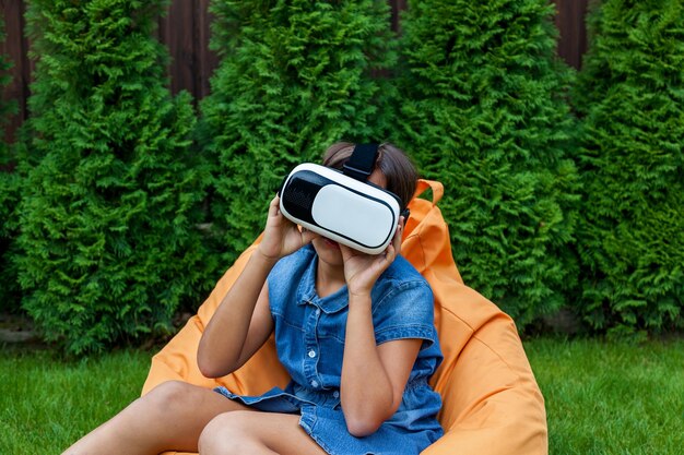 Ragazza con occhiali per realtà virtuale nel parco