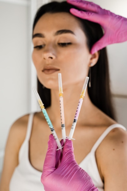 Girl with vitamin cocktail syringes for injections Mesotherapy injections of vitamins enzymes hormones and plant extracts to rejuvenate and tighten skin and remove excess fat