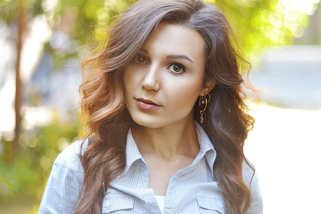 Girl with wavy beautiful thick healthy hair on a background of nature