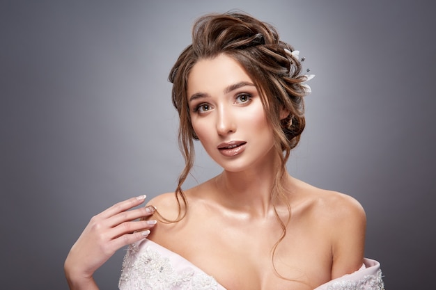 Girl with wavy hair looking to the camera and touching her shoulder