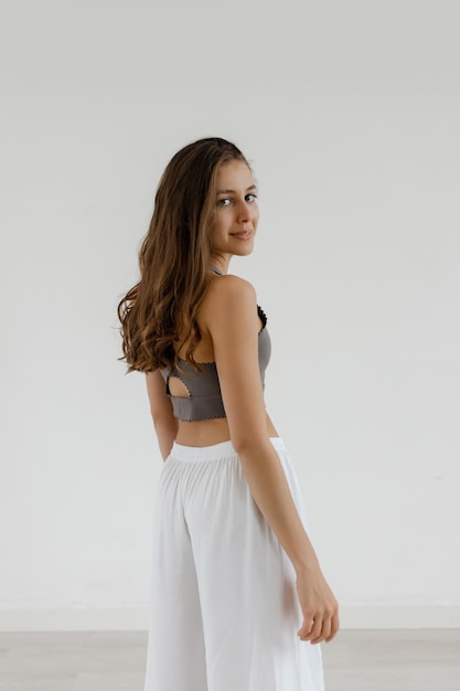 Girl with wavy hair stands smiling after a workout