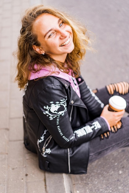 girl with white curly hair with a glass of coffee.