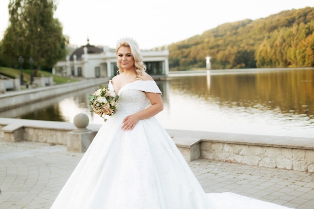 Girl with white hair said on the nature, in the forest, on the lake. Wedding dress.