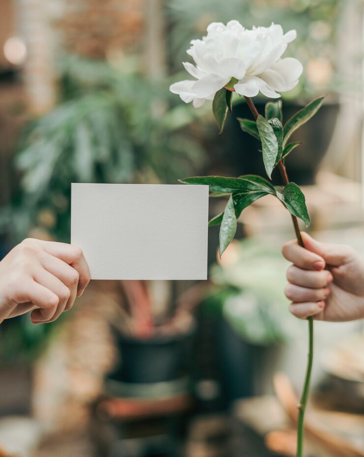 Photo girl with a white paeonia snowboard flower and a card