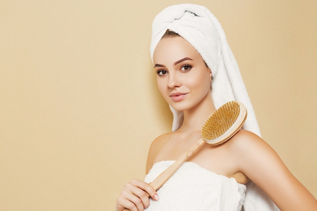 Girl with a white towel on her head on a beige background