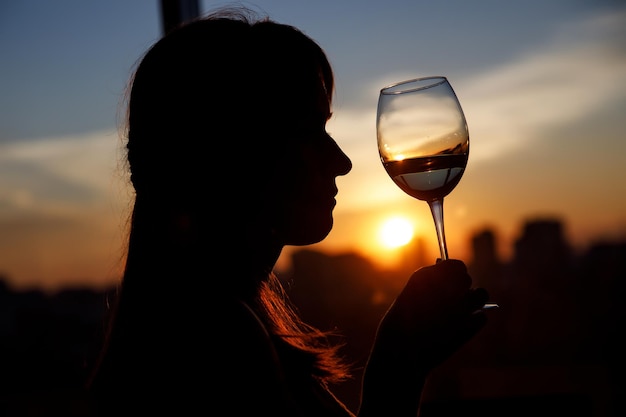 Foto ragazza con bicchiere di vino silhouette nera