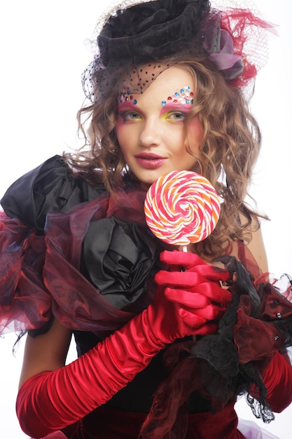 창의적인 화장을 한 소녀가 사탕을 들고 있다