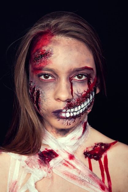 Photo girl with wounds on her face, bloody stains, makeup for halloween, girl