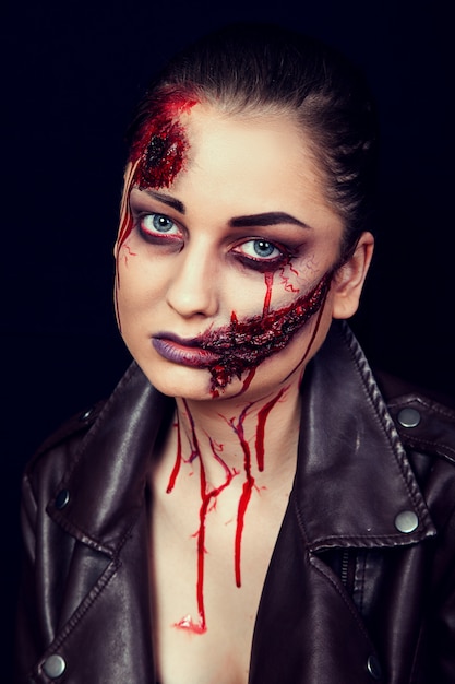 Girl with wounds on her face, bloody stains, makeup for halloween