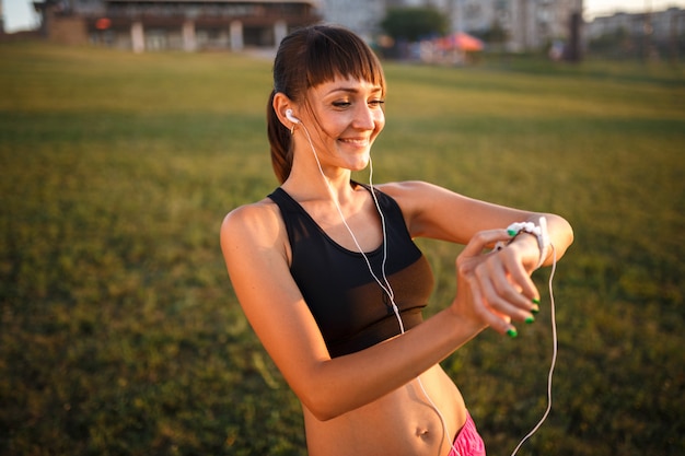 Girl with wrist fitness bracelet outdoors