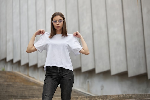 Girl or woman wearing white blank t-shirt with space for your logo, mock up or design in casual urban style