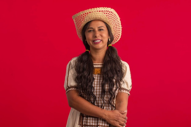 Photo girl women with typical costumes of festa junina in studio photos on red background brazilian june festival