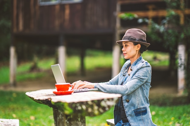 Girl working and driniking coffee on table in vacation holiday time on hills nature