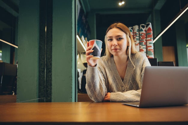 Girl working at her laptop sitting in the cafe