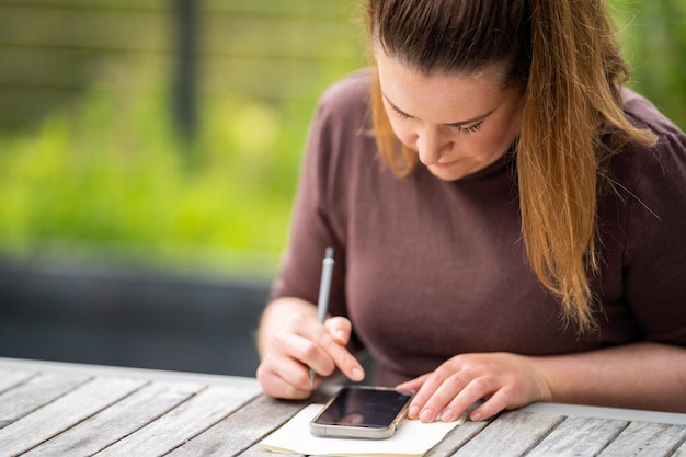 Girl working on her phone working remote in the country