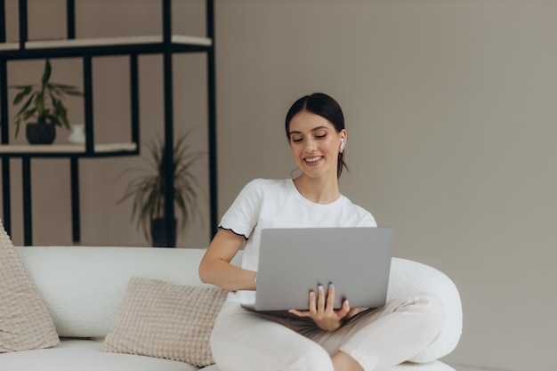 Ragazza che lavora al computer portatile da casa o studente che studia da casa o freelance oppure sta guardando un video o sta usando internet