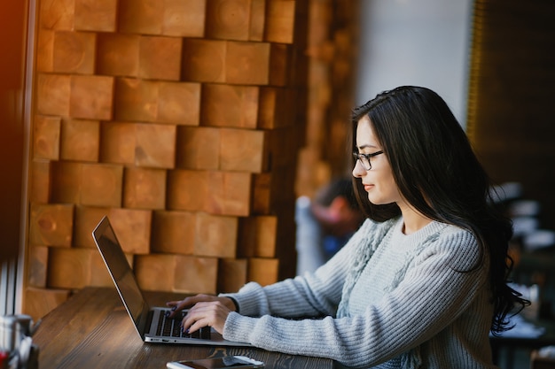 Girl working on a laptop at a restaurant