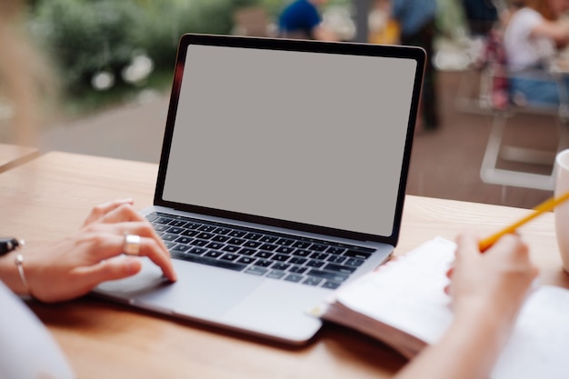 girl behind working behind laptop with blank screen