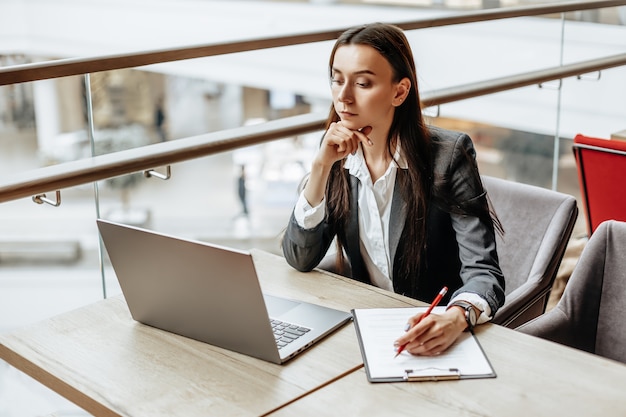 Girl works on a laptop in the office