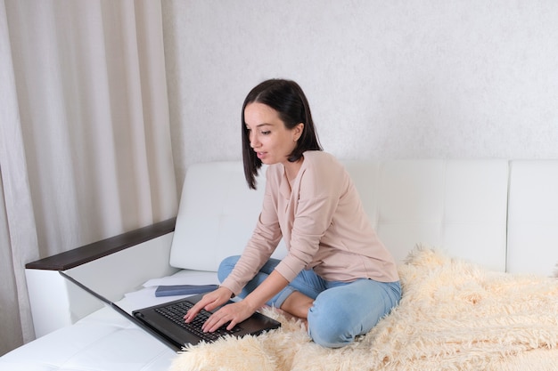 La ragazza lavora con un laptop senza uscire di casa.