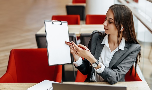 Girl works on a laptop in the workplace. Businesswoman shows and explains the goals and objectives for the business.