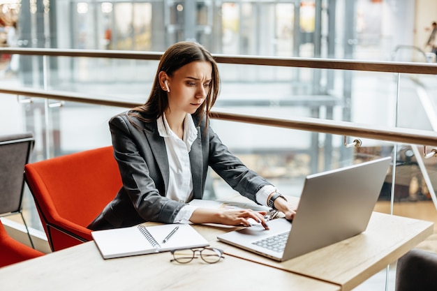 Girl works on a laptop in the workplace.