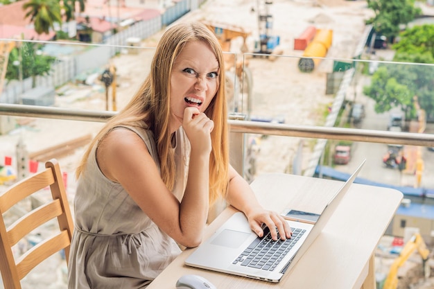 The girl works in a noise on the background of construction work in the noise concept