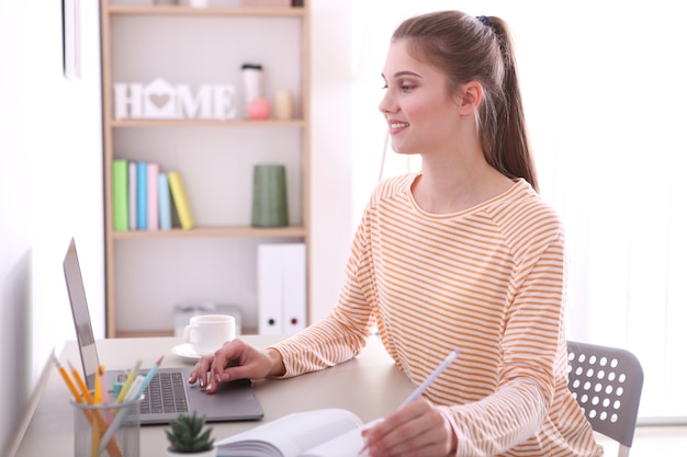 The girl works remotely from home using a modern laptop