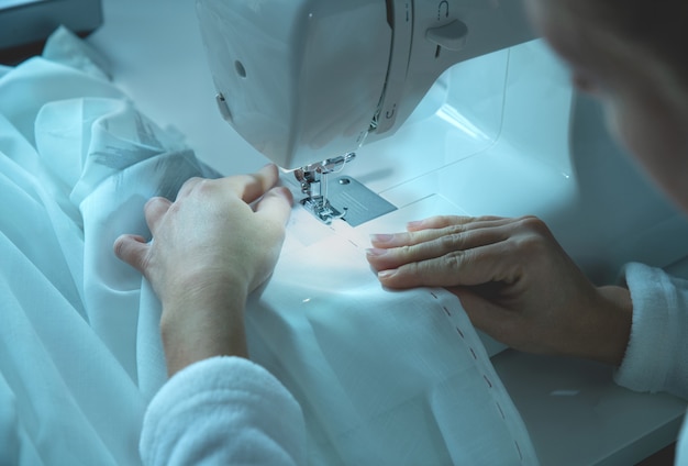 Girl works on a sewing machine