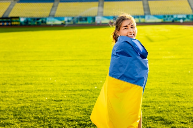 A girl wrapped in a flag on a soccer field