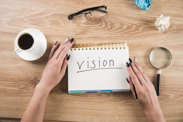 Girl writes a vision in a notebook. writing vision