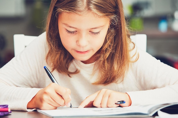 Photo girl writing on book at home