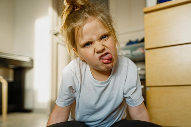 写真 自宅でしかめっ面をする女の子は顔を作ります